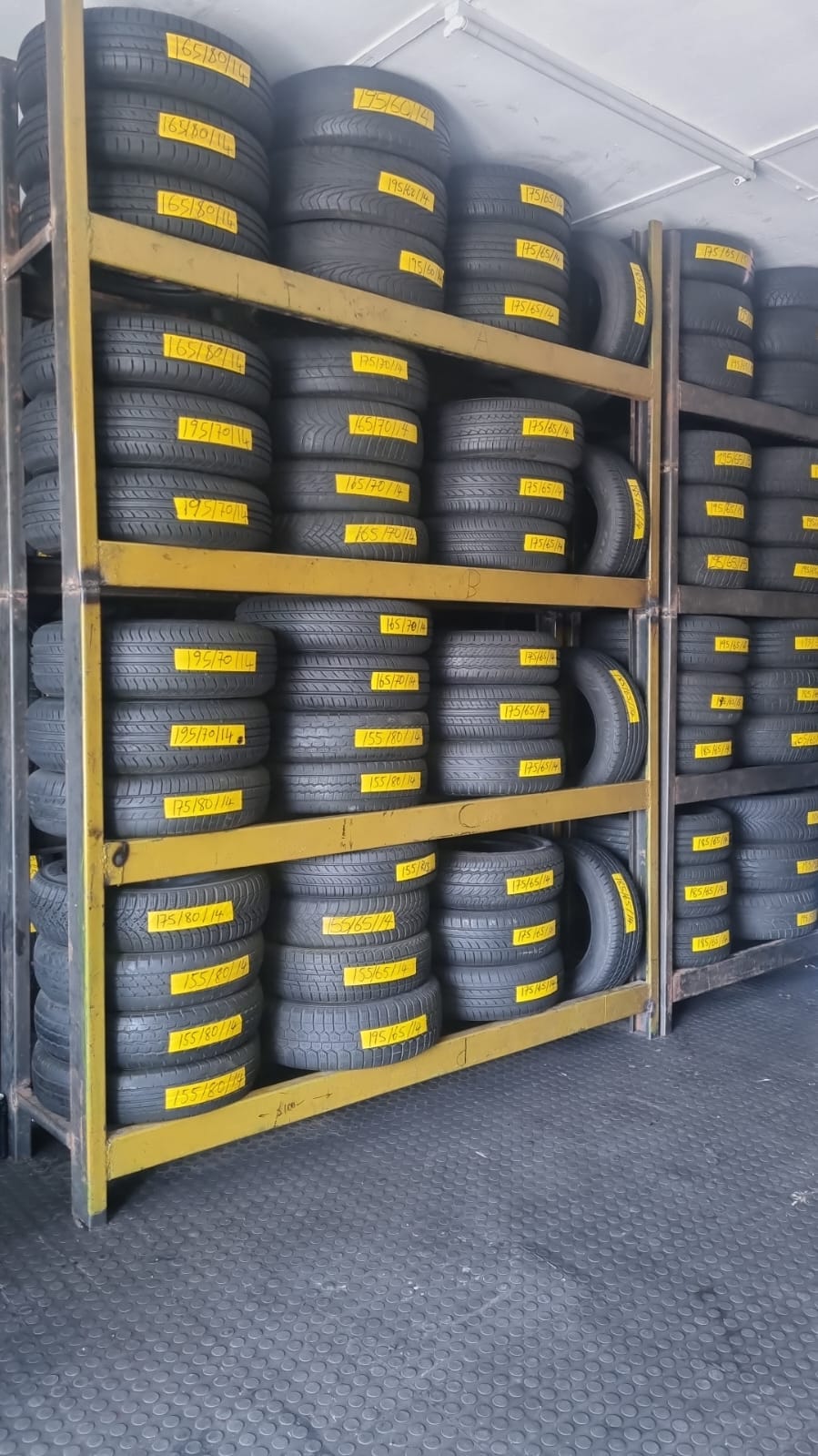 Yellow racks holding used tyres labelled by size