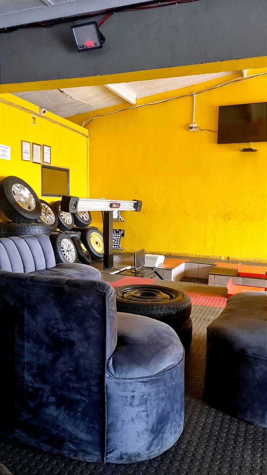 The customer waiting lounge at Bong's Tyre Centre with seating and a television