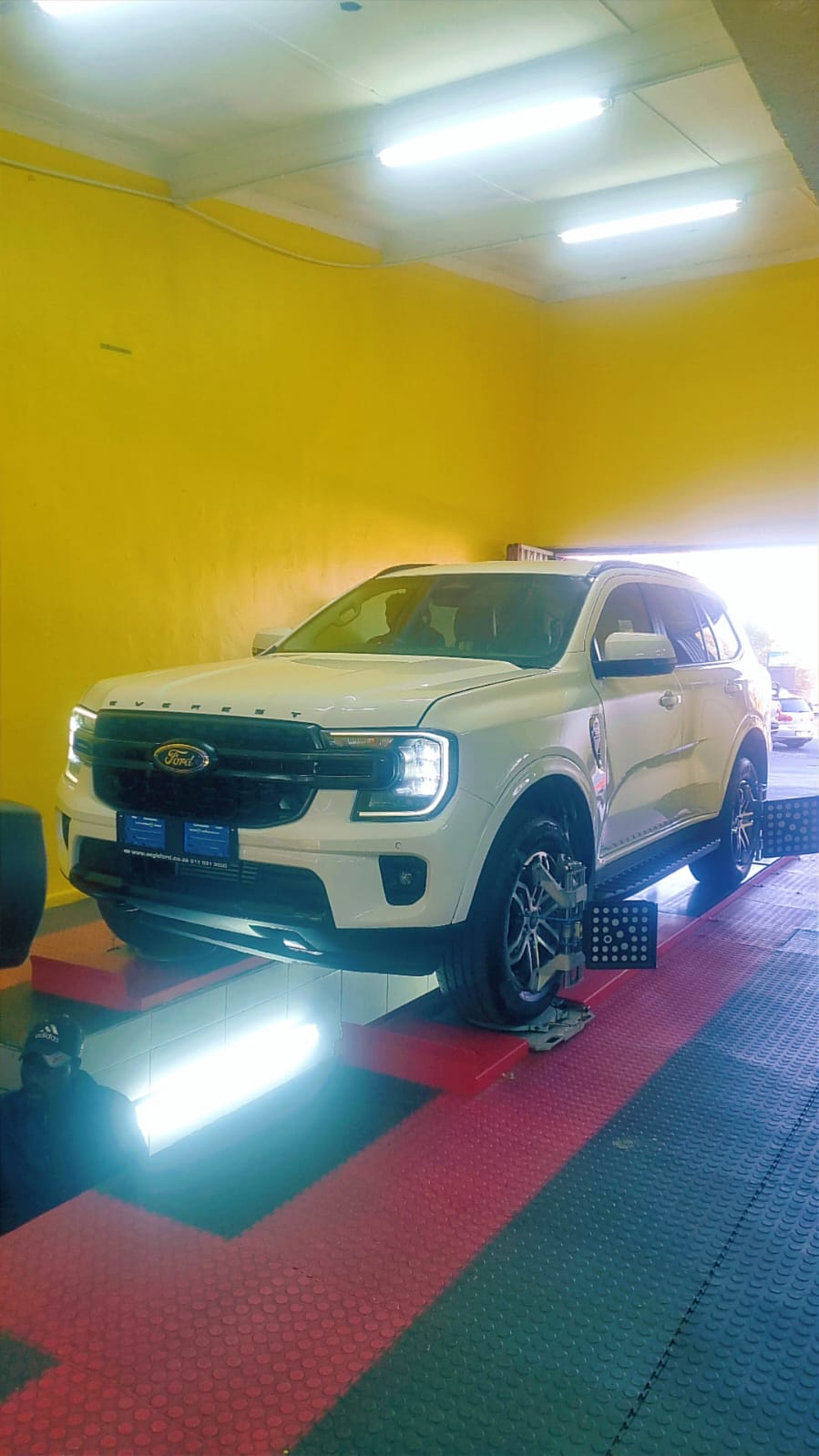 A white Ford Everest on the wheel alignment ramp at Bong's Tyre Centre